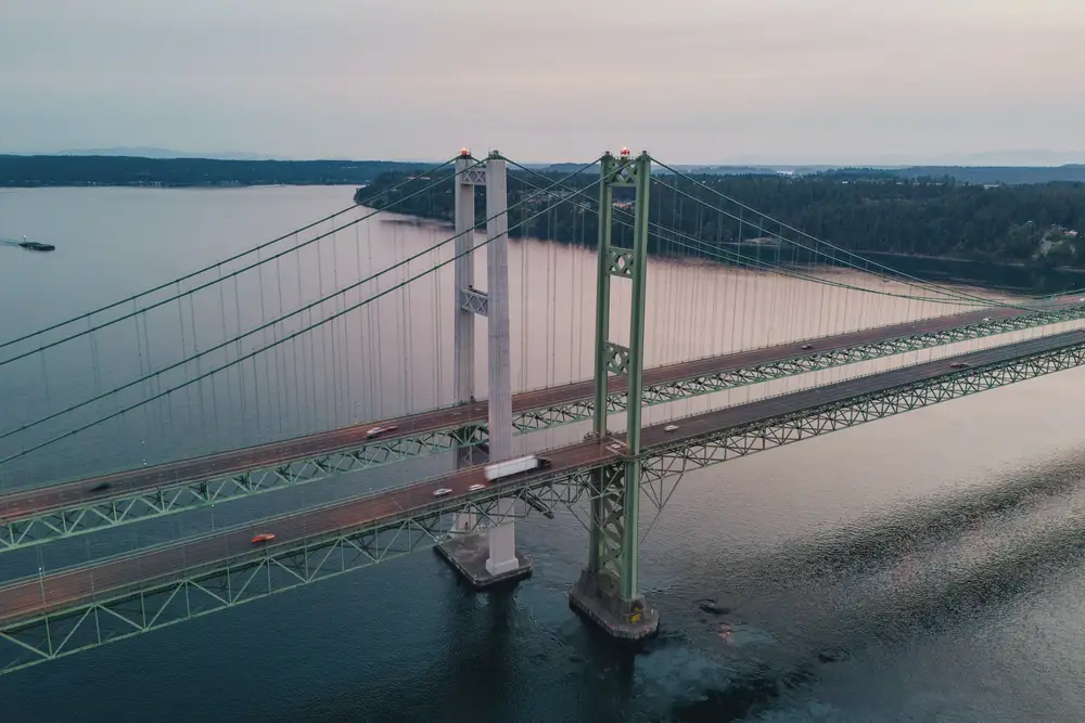 Twin suspension bridges over a narrow strait, seen from above