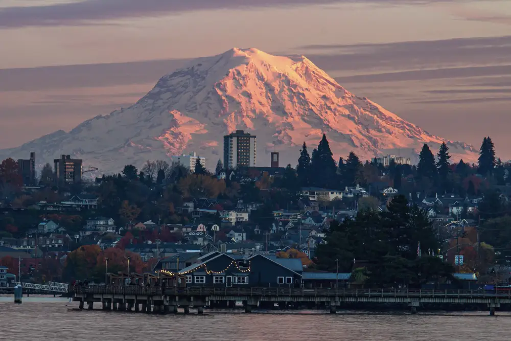 Mount Rainier glowing above a city skyline at sunset